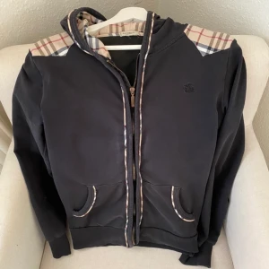 Vintage Burberry tröja - Vintage burberry luvtröja. Köpt secondhand så kan ej garantera äkthet men ser i alla fall äkta ut. Passar Xs-S. Den sitter ganska slouchy oknäppt men blir tightare när man stänger dragkedjan