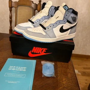Jordan 1 University blue - Hej säljer mina jordans, dom är använda i ca ett halvår och är i cond 7/10, samt i storlek 43. Skorna är äkta och köpta från SNS om fler frågor å bilder är det bara att höra av sig Tar även emot trades mot jordan 4s och bapestas