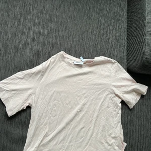 Rosa T-shirt  - Säljer denna ljusrosa t-shirten från Weekday, den är mer rosa i verkligheten men kameran gör så att den ser ljusare ut☺️ Frakten betalas av köparen!❤️