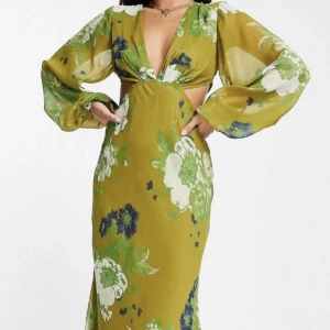 Maxiklänning - Grön blommig Maxiklänning från Asos Petite, med knytning i ryggen. Storlek 34/xs. Räcker mig ner till fötterna (är 165cm) utan klackskor. Använd en gång som balklänning, tvättad därefter. Köpare står för frakt😊