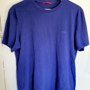 Prada t-shirt - Prada t-shirt i fin mörkblå färg. Äkta, köpt på NK för många år sedan. Använd men fortfarande i rätt bra skick.