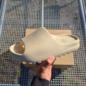 Yeezy Slide Bone - Hej!  Säljer helt nya, otestade Adidas Yeezy Slides "Bone". Har storlek 42. Kvitto samt alla original saker medföljer. Skriv ifall ni har några frågor 😁