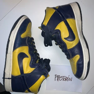 Nike dunk Michigan 1999 - US 9 Från 1999 i gott skick förutom lite heeldrag  Äkta läder jämfört mot dagens vegan läder. Ta chansen att äga ett par Nikes från första re-releasen av dunks. Historia