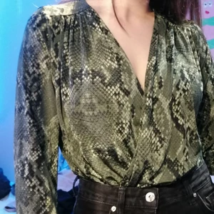 Body med orm-mönster på - Grön body med orm-mönster på och v-neck. Aldrig använd. Kontakta för mer bilder 💚