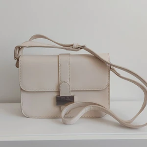 Beige väska - Axelremsväska i beige från Mango. Justerbar axelband, väskan har 2 fack på insidan. Priset är exklusive fraktavgift. 