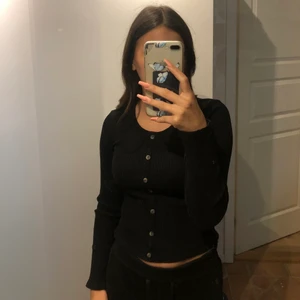 Svart tröja - Svart tröja från H&M i stl Xs, ribbat material med knappar där fram