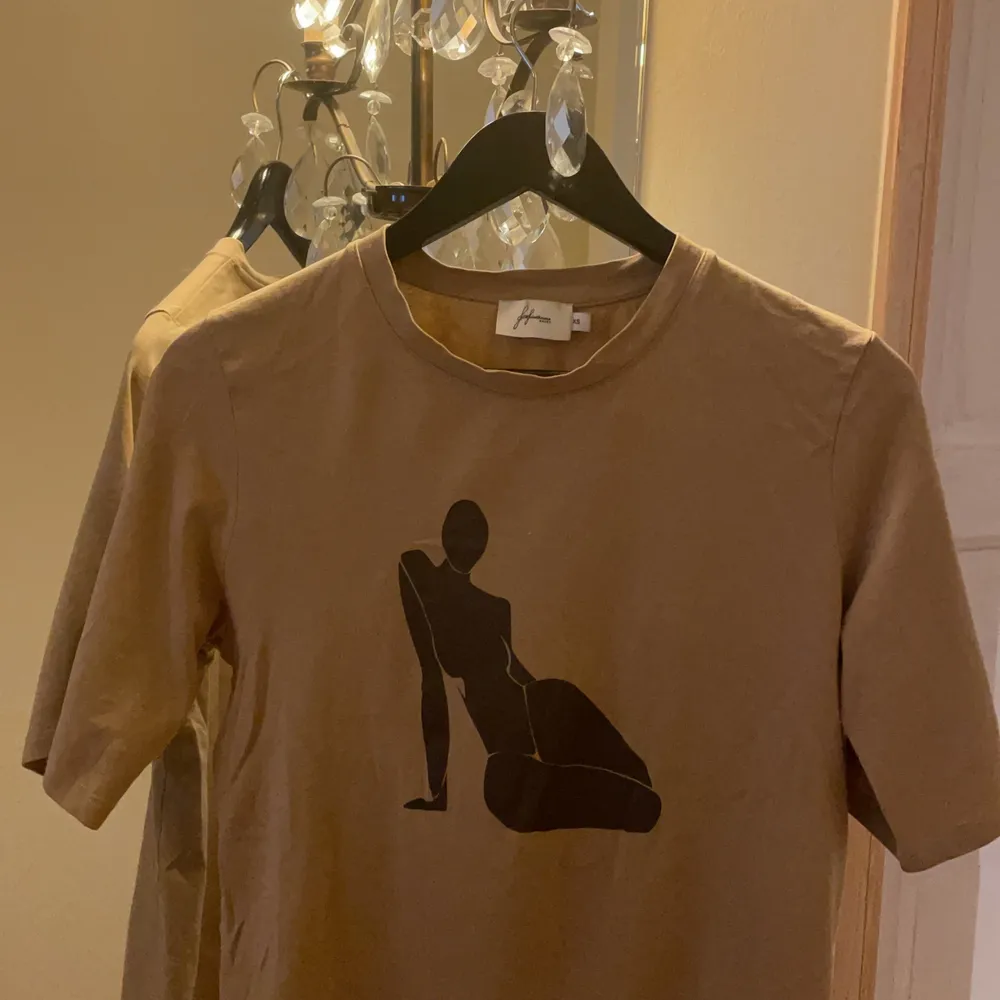 T-shirt från NaKD storlek XS i brunt material. Tjockt material för en t-shirt och väldigt bekväm. Lite ”oversize” med långa t-shirtärmar och lite box-form. Sedan fint tryck. Säljer för den inte kommer till användning. Skulle även passa någon med S-M. T-shirts.
