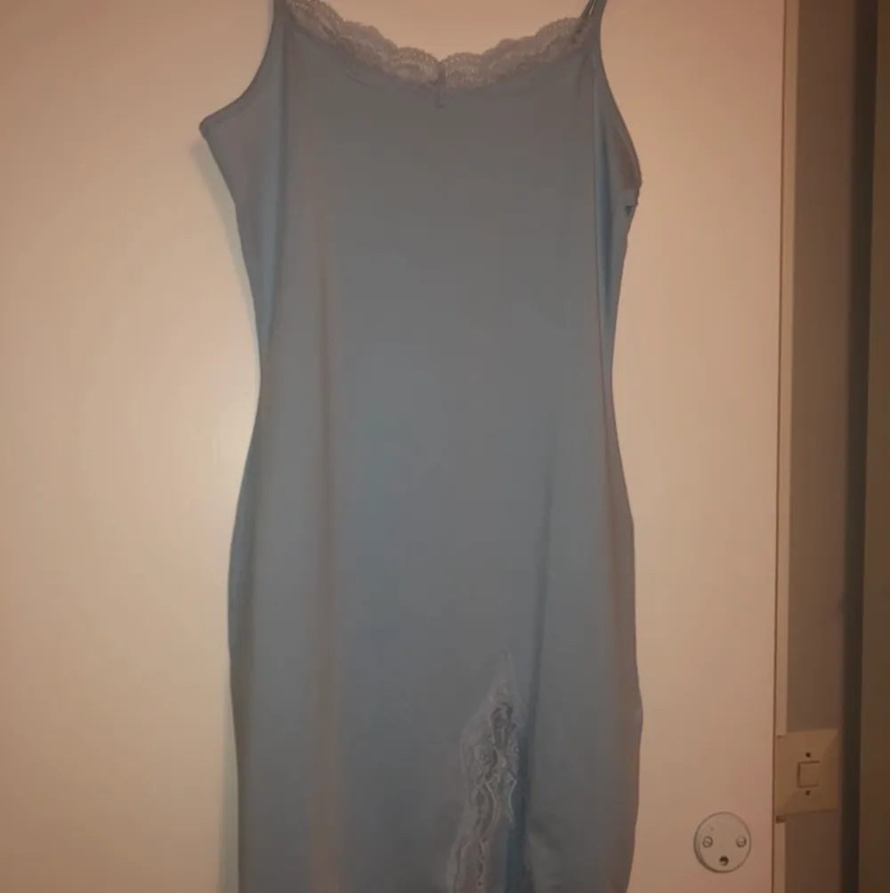 Blå klänning med spets detaljer, liten slits . Klänningar.