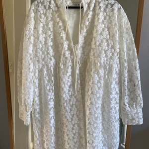 Klänning Zara  - Vit klänning i fint mönster från Zara. Använd 1 gång. 3 Knyten fram som man kan välja att ha öppna eller knutna.