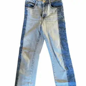 Högmidjade, tvåfärgad, raka Maje jeans i storlek 38. De är använda och lagade vid rumpan (se bild).