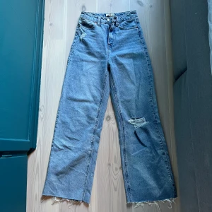 Jeans med slitningar - Säljer dessa jeans med slitningar från HM. Får dem ej över rumpan så därför inga bilder hur de ser ut på hehe. Strl 34 och passar inte mig som oftast har 36/S. Perfekt längd på mig som är 160. Frakt på ish 50 tillkommer🥰💕 Bild nr 2 visar färgen bättre!