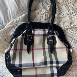 en burberry liknande handväska med rutigt tyg och ”ormigt” läder på handtaget etc. känns som sprillans ny och har inga defekter! frakt 66 kr, skriv för fler bilder o info!💋