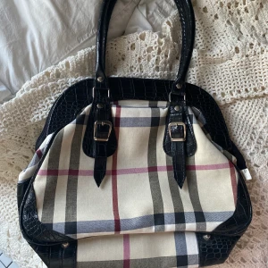 burberry liknande väska - en burberry liknande handväska med rutigt tyg och ”ormigt” läder på handtaget etc. känns som sprillans ny och har inga defekter! frakt 66 kr, skriv för fler bilder o info!💋
