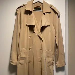 Super skön trenchcoat i mjukt material. Bandet i midjan saknas annars inga konstigheter. Storlek Xs från bikbok.