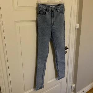 Jeans från NA-KD  - Säljer ett par coola jeans från NA-KD. I fint skick. Storlek 38. Modellen heter Stone Wasted Skinny Jeans. 90% bomull, 8% polyester och 2% elastan. 