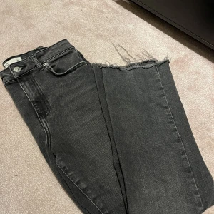 Jeans från GinaTricot - Bootcut jeans från Gina. Mörkgrå med lite trådar i slutet. Köpte för några månader sedan men i väldigt bra skick! Passar mig som är 160,5 i längden.