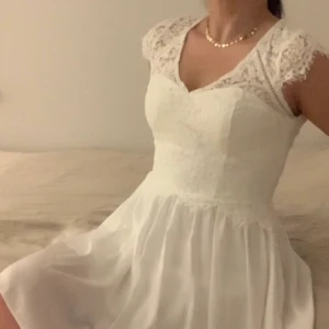 Vit klänning - Jätte fin knälång vit klänning till både student, konfirmation eller annnat 🍾🥂. Mycket fina spetsdetaljer ✨. Var tänkt till studenten, men kunde inte lämna tillbaka den, sprillans ny 600kr. De står st34, modellen är lite större. Passar därför st36 också
