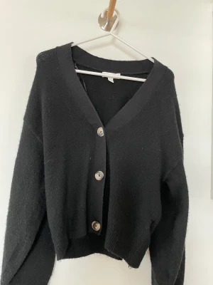 Stickad kofta  - Använd 1 gång från HM. Svart med fina knappar! Xs men passar S