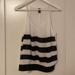 Black and white tank stop. Size S. Pleated and very lightweight. Has A V-neck. Great for spring. No stains/holes. Hartley ever worn.