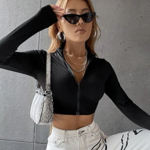 Svart topp med dragkedja - Säljer denna svarta snygga toppen med dragkedja. Den är långarmad och cropped i modellen. Den är använd några gånger men är i fint skick. Storlek Xs Köparen står för frakten🐻🐻🐻