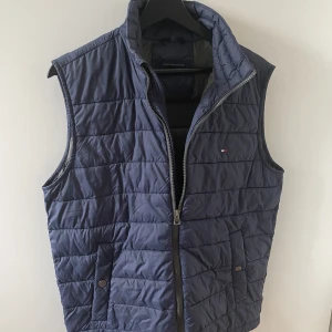 Tommy hilfiger dunväst - Marinblå Dunväst från Tommy hilfiger, herrmodell men passar som unisex. Bra skick.