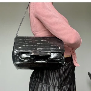 Nunoo Honey Croco Väska Äkta Läder Onesize - En ÄKTA NuNoo Honey Croco väska med krokodilskinnsmönstrat äkta läder. Det medföljer en avtagbar justerbar axelrem som är längre 🖤 B: 24 H: 16 D: ca12 Den är som ny❣️ skriv för fler bilder