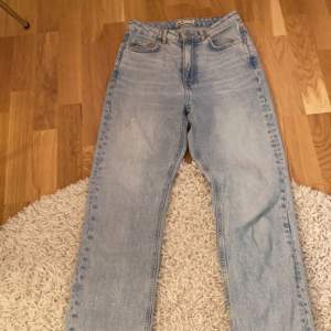 Blåa jeans med slits, använda