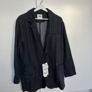 DENIM KAVAJ ZARA - Kavaj i svart denim - strl M.  Aldrig använd då jag köpte samma i två olika storlekar och denna var tyvärr lite för liten för mig och hann inte skicka tillbaka den.  Super fin och använder min som jag behöll hela tiden.  Köpt för 699kr. 