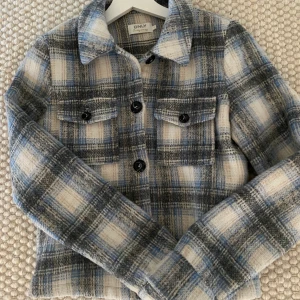 Ylle jacka fr only! Strl Small  - Kort rutig jacka- Knappar framtill- Tvà bröstfickor med klaffar- Jackan innehäller ylle- Längd: 56 cm i storlek S- Modellen bär storlek S