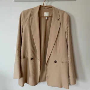 Beige kavaj - Beige kavaj från H&M, storlek 36. Säljer för att jag har mågna andra kavajer. Knappt använd!