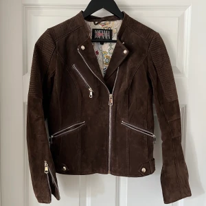 Skinnjacka från Jofama - Brun läderjacka från Jofama av Kristine Ullebø. Yttertyg är riktigt läder och innertyget är av siden. Använd men i mycket fint skick. Har tyvärr mest hängt i garderoben på senaste så den förtjänar en ny ägare!  