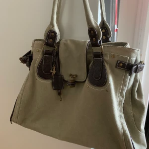 Grön väska  - Säljer pga använder inte, den är rätt sliten i banden därav priset 