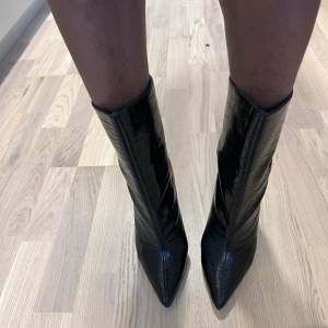 Oanvända boots med ormskin