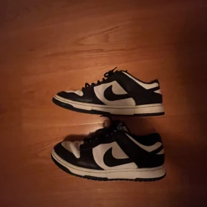 Nike dunk panda - Ett par dunk pandas som var köppta på soleplus för 2800 ca 2 år sen. De är ganska använda men går fortfarande att ha på sig. Finns heeldrag och små hål på insidan över ankeln. 