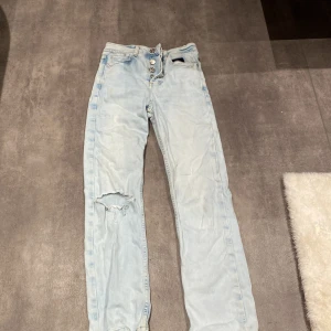 Byxor  - Säljer blåa jeans med hål i, dem har ett litet hål vid knapparna men inget som syns, 