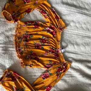 Orange blommig croppad topp i storlek S - Blommig croppad topp i storlek S från H&M. Frakten ingår inte i priset!