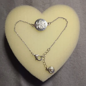 Armband  - Ett silvrigt armband. In graverat "grl pwr" vilket står för girl power, på andra sidan en stjärna. Längesen den användes, lite misfärjad på några ställen men för övrigt bra skick. 