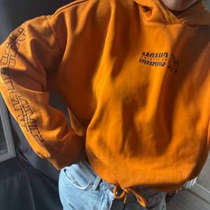 Orange hoodie med snörning längst ner, storlek M alltså lite oversized för mig som vanligtvis har S,  väldigt skönt material