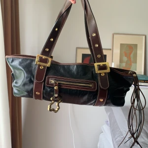 Tous väska - Rymlig, svart Tous väska med bruna och guldiga detalijer, orange innuti. 