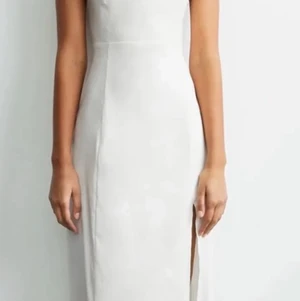 Vit långklänning öppenrygg  - Extremt snygg vit långklänning med öppen rygg och öppen vid ena benet. Var lite för stor för mig