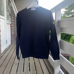 Mörkblå Stone Island tröja storlek 156 cm - Tröjan är köpt på junioravdelningen på NK i Stockholm i julas. Tröjan är bara använd ett fåtal gånger, dock finns det en liten fläck som ger en mörkare blå färg ganska mitt på tröjan. Tröjan köptes för 1600 kr. 