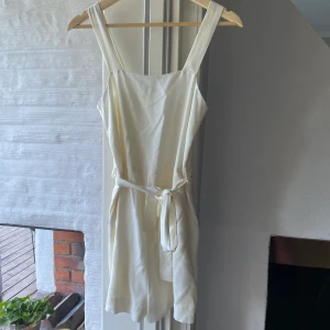 Vit byxdress - Vit byxdress i storlek 34. Aldrig använd, den har tyvärr bara blivit hängandes i garderoben! Jag kan antigen möts upp centralt i Stockholm eller norr om Stockholm, annars får köparen stå för frakten!😊