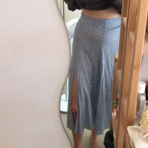 Somrig blå kjol med vita blommor  - Jättefin midi kjol med blommor från Hm. Använd 1 gång. Storlek 36.