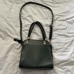 Mörkgrön väska  - Köpt secondhand. Lite sliten på vissa ställen, men överlag bra kvalitet.