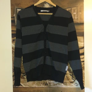 Grå- och svartrandig kofta - En grå och svartrandig kofta/väst från double xx som går att stänga med knappar. Aldrig använd och köpt för 100 :))