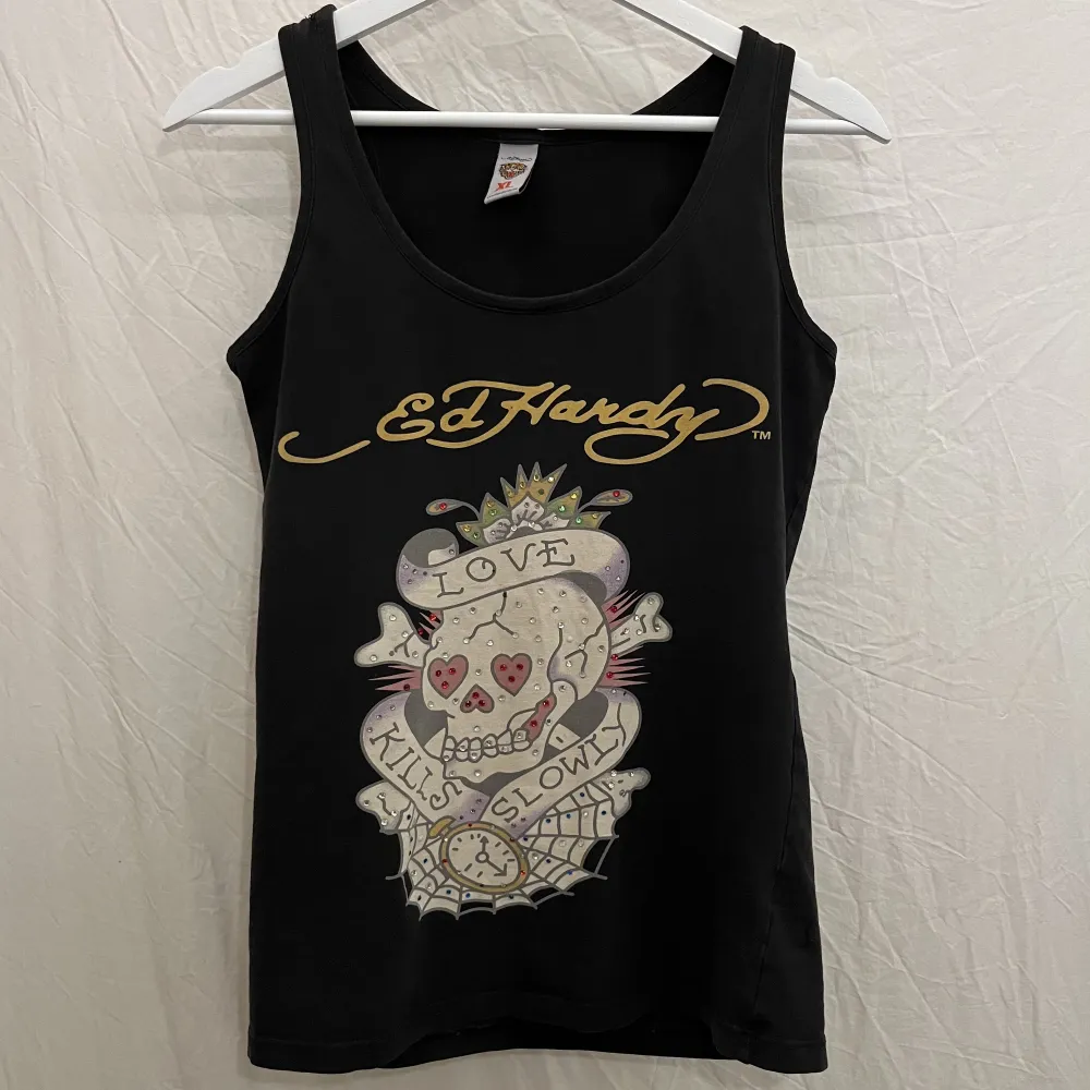 Svart linne med tryck från Ed Hardy. Fint skick. Märkt som XL, men sitter så här på någon som brukar ha XS/S. . T-shirts.