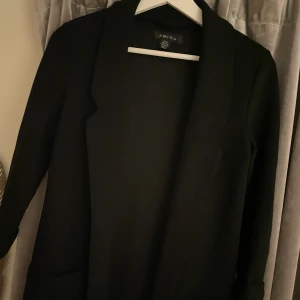 Svart kavaj  - Svart kavaj från New Yorker i finribbad modell med fickor i strl 36