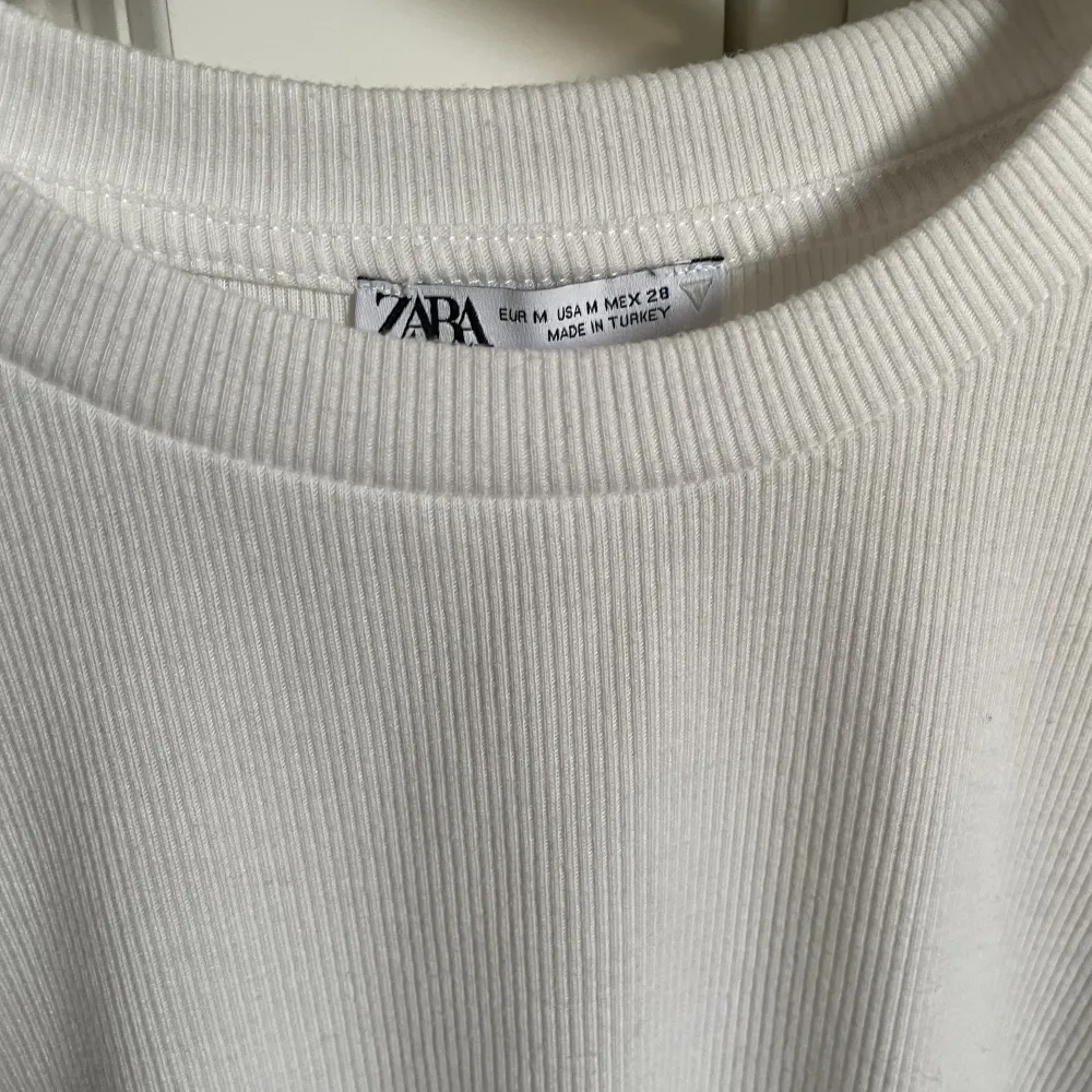 Vit tröja från Zara med drag/knytdetalj i sidan. Superfint skick men säljer då den är för liten. Storlek M men passar både mindre och större beroende på hur man vill att den sitter., pris kan diskuteras vid snabb affär🫶🏼. T-shirts.