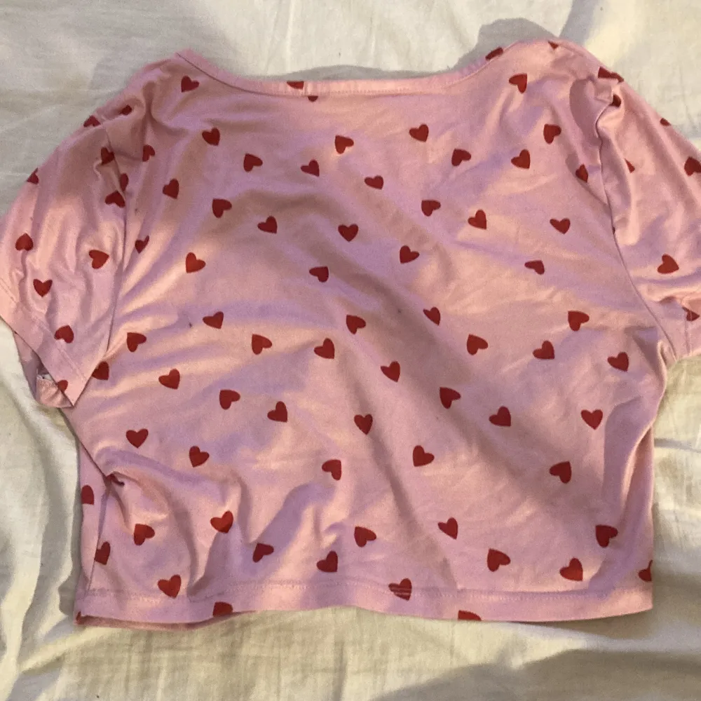 Rosa crop top med knappar och hjärtan på storlek S/M från SHEIN stretchig. T-shirts.