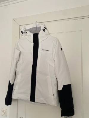 Skidjacka från Peak Performance - Säljer mina knappt använda skidplagg från Peak Performance. Skidjacka i strl S. Använd 2-3 ggr och har någon enstaka liten fläck (går säkert att tvätta bort), se bild. Yttertyg: 100% återvunnen Polyester. Fyllning: 100% polyester. Säljs för 700 kr. 